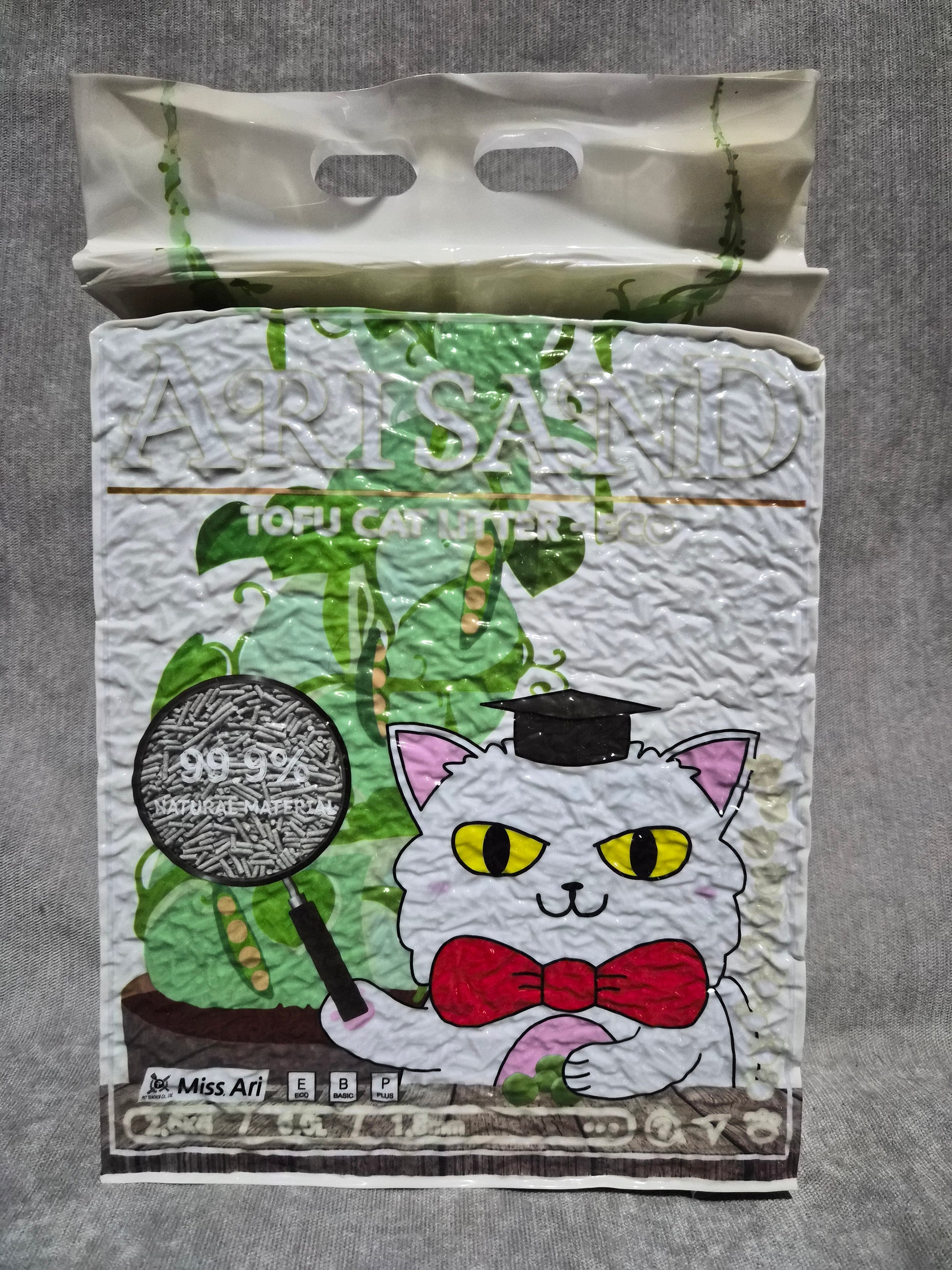 Cartoon cat design on a piece of paper with a plastic bag beside it on a gray surface