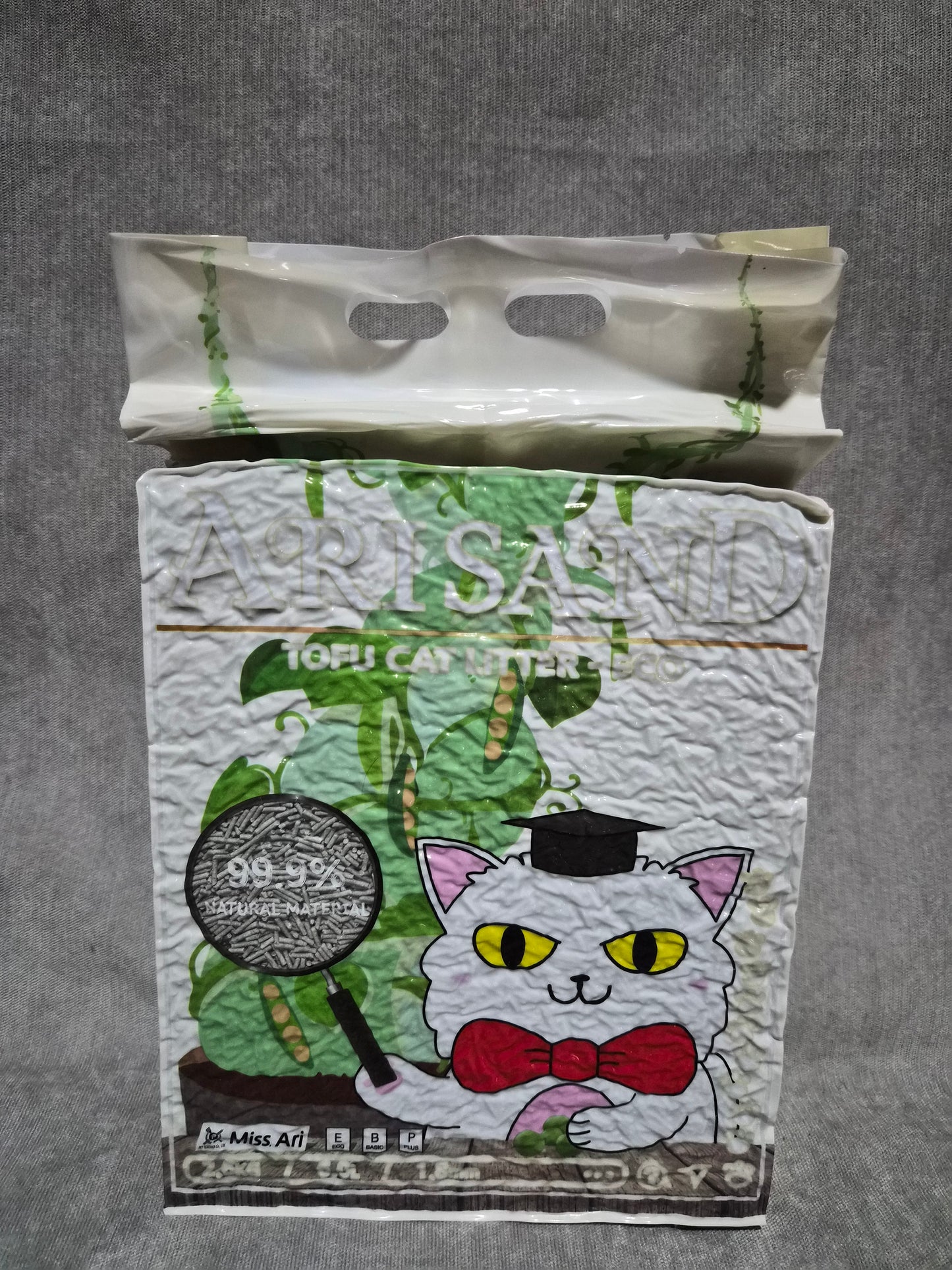 Cartoon character design on a textured paper with a plastic bag beside it on a gray surface